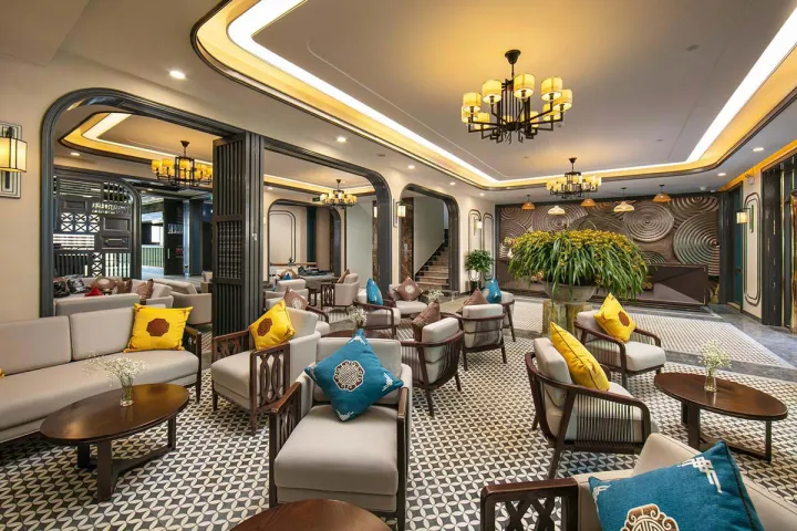 Lobby at DeLaSol Phat Linh Hotel in Sapa Vietnam with seating area, reception desk and decorative wall