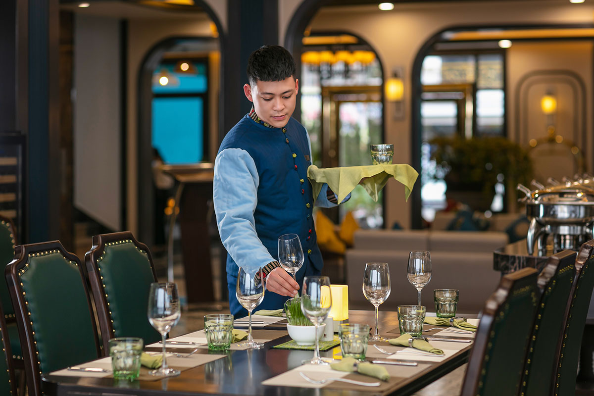 Restaurant area at DeLaSol Phat Linh Hotel Sapa with waiter setting the table