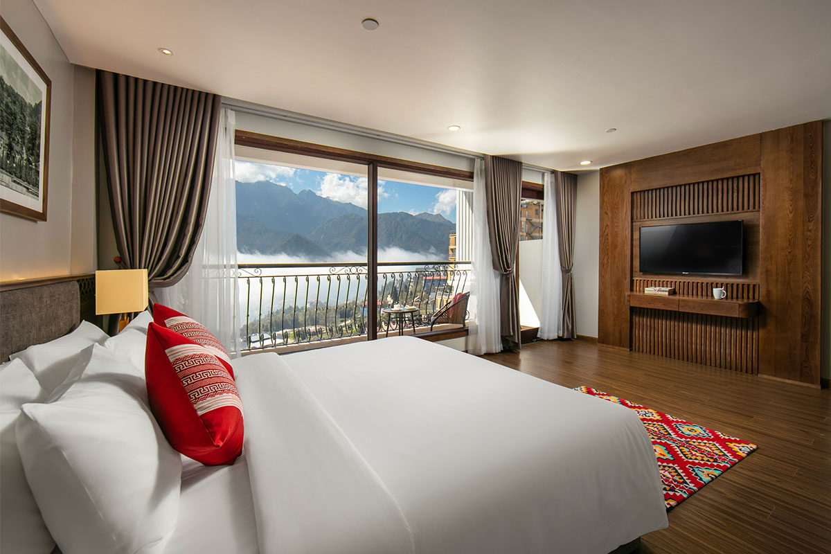 Hotel room at DeLaSol Phat Linh Hotel Sapa with double bed and large window to balcony