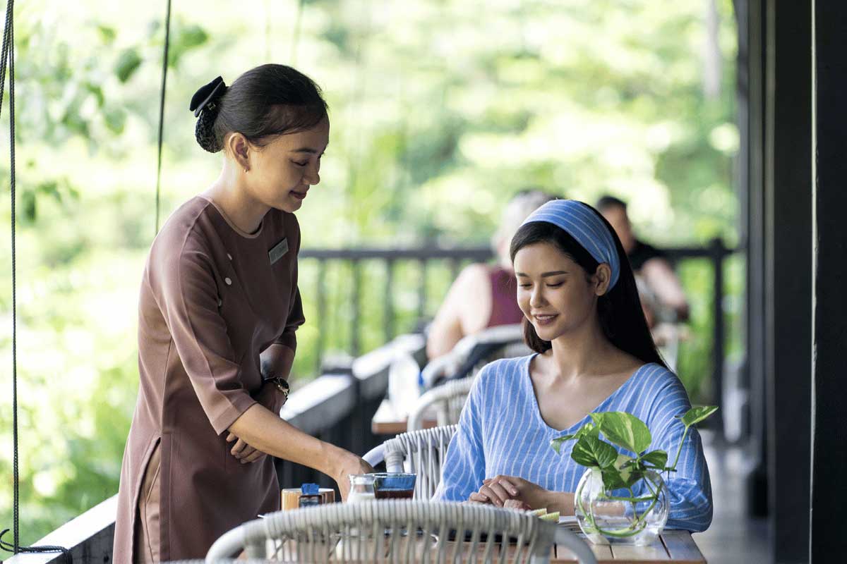 Staff member serving a guest at the restaurant of Nam Nghi Coral Peninsula Phu Quoc Resort