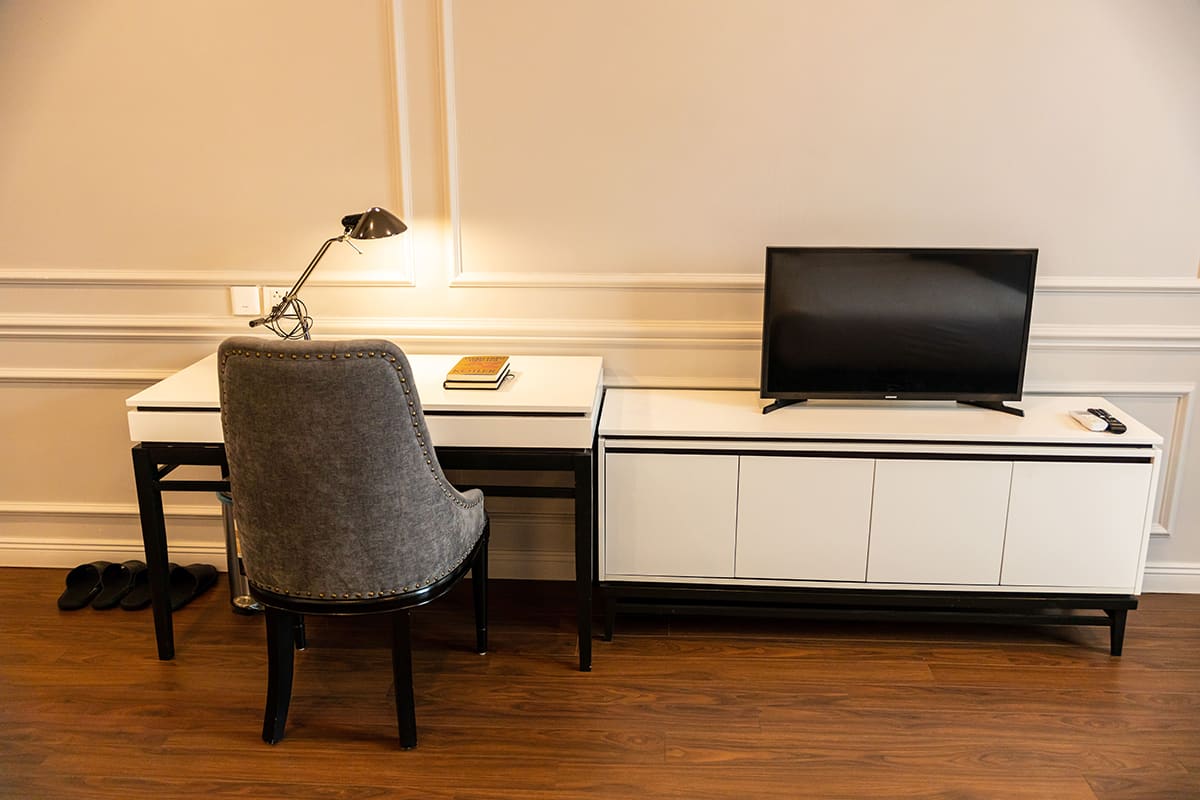 Desk with chair and television in a room at Thien An Hotel Viet Yen