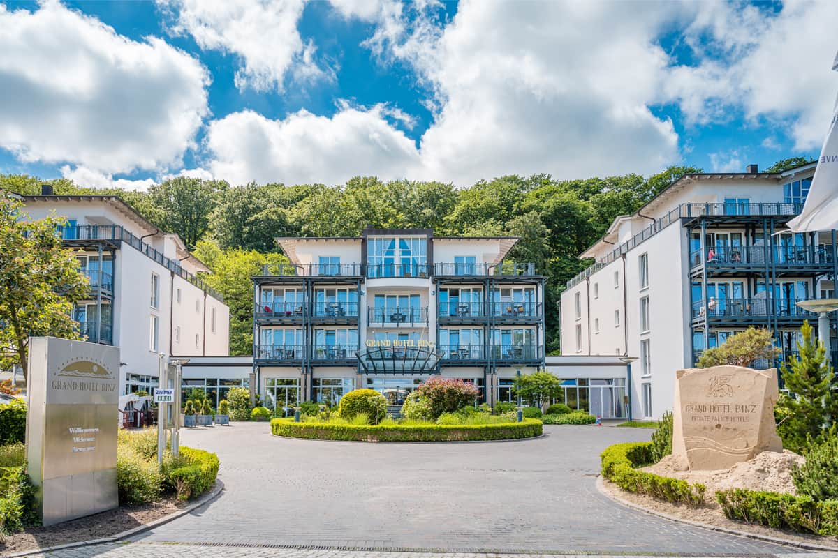 Entrance of Grand Hotel Binz on Rügen with hotel building, driveway and landscaped garden